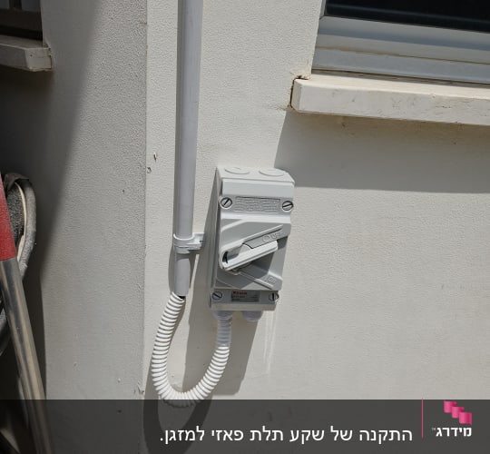 מתג חשמלי מותקן על קיר חיצוני ליד חלון